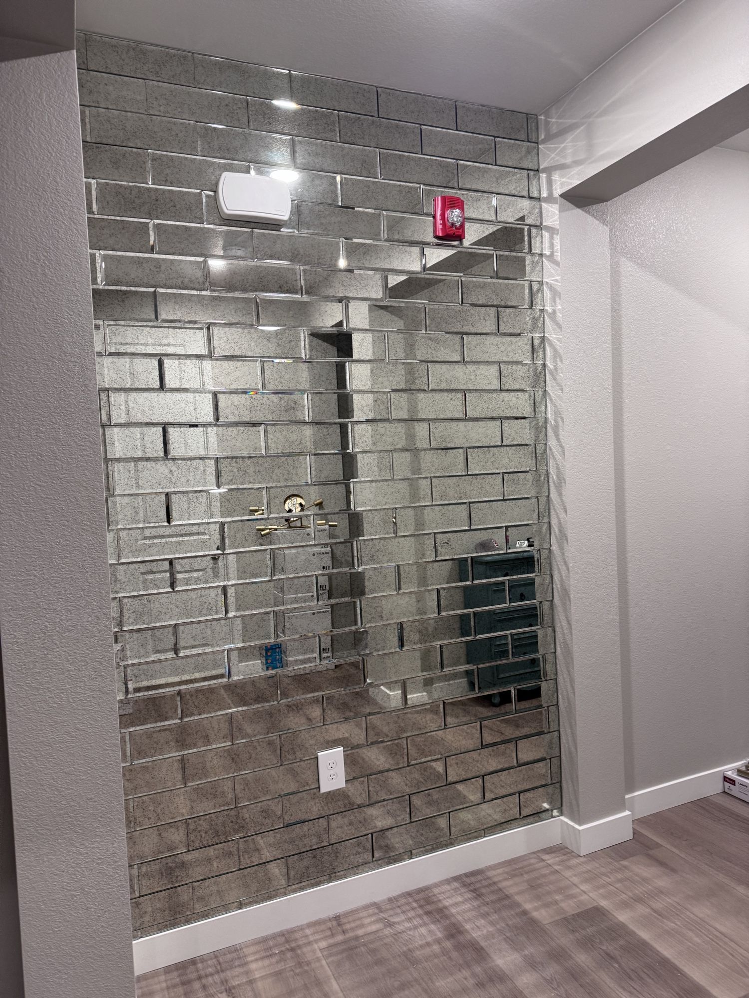 Interior wall covered floor to ceiling in mirrored tiles in a brick subway pattern